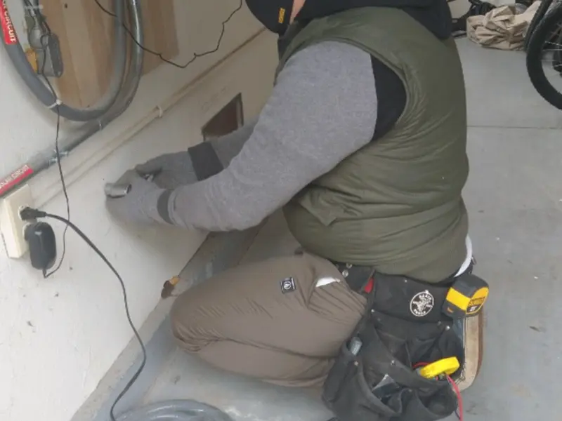 Electrician performing outlet wiring in a Whitesboro garage